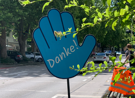 Eine blaue große Hand mit einem darauf zu lesenden „Danke“